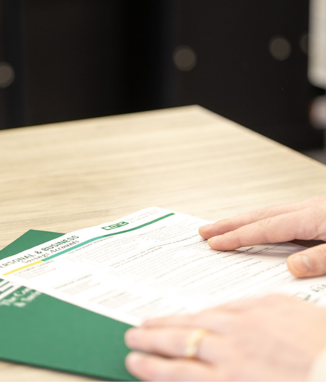Customer reviewing CSB personal and business savings account information sheet