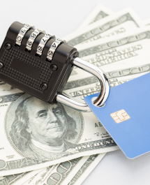 Padlock securing a credit card and cash, symbolizing financial security.